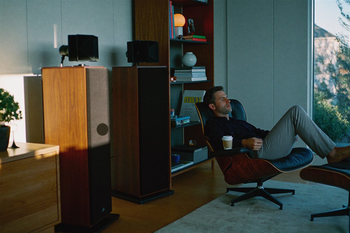 A calm modern listening corner — floor-standing speakers flanking a low cabinet in soft morning light